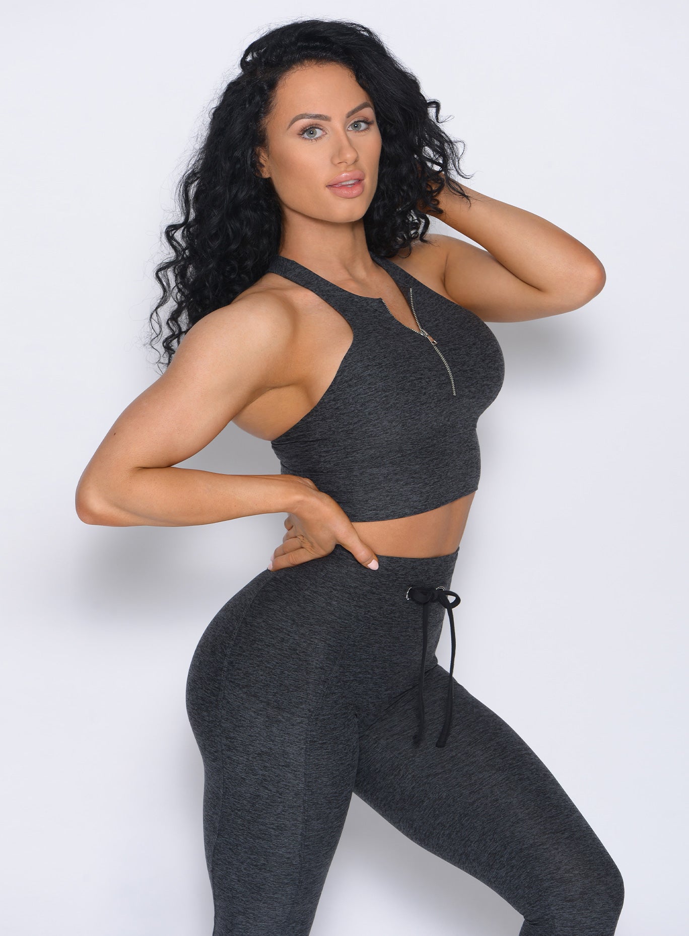 Right side view of the model angled right in our edgy longline bra in charcoal color and a matching leggings