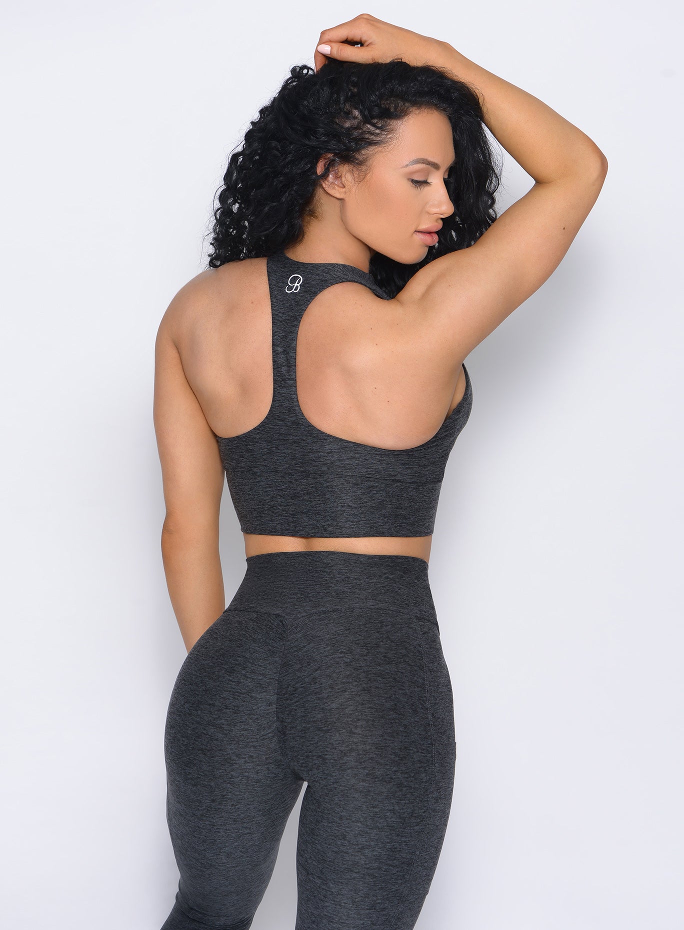 Back view of the model in our edgy longline bra in charcoal color and a matching leggings