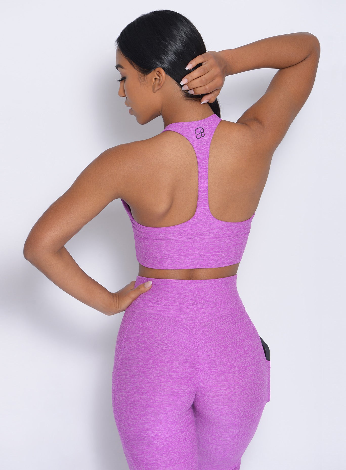 Back view of the model in our edgy longline bra in purple rain color and a matching leggings