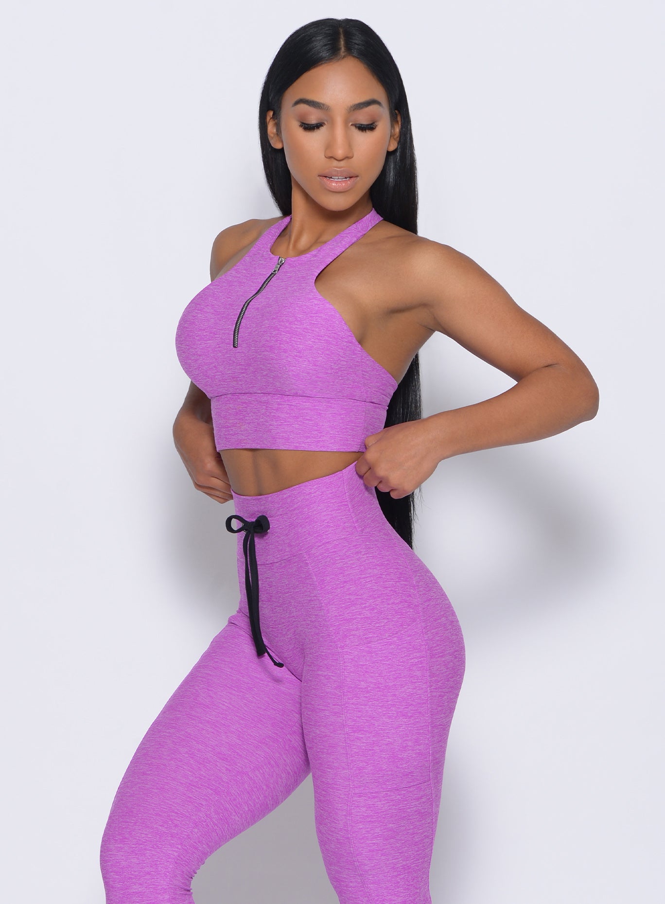 Left side view of the model angled left wearing our edgy longline bra in purple rain color and a matching leggings