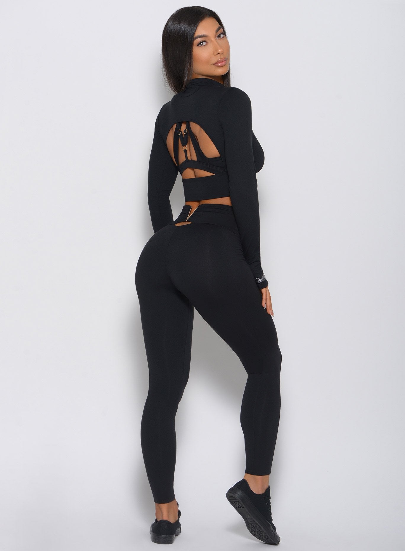 Back view of the model in a black leggings with a V back design 