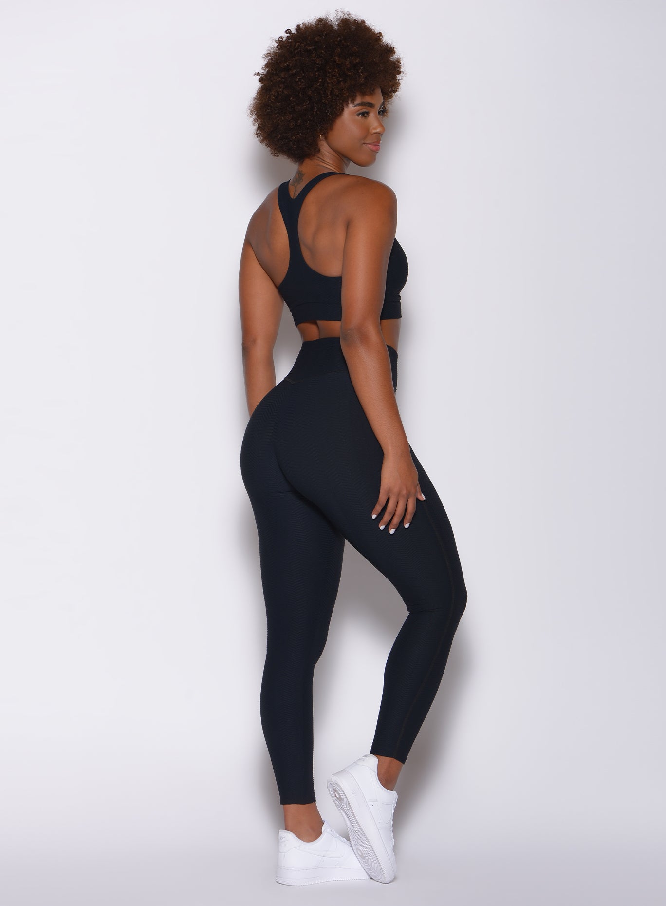 right side profile view of a model in our Chevron Leggings in jet black color and matching bra
