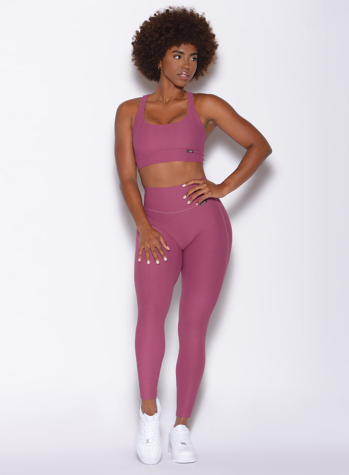 front profile view of a model wearing our Chevron Leggings and Chevron Sports Bra in Rose Wine color with her left in her waist
