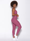 Right side view of a model facing to her right wearing our Chevron Leggings in Rose Wine color and a matching bra