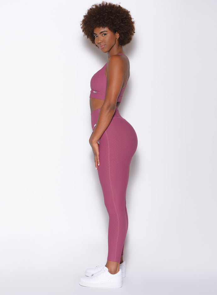 Left side view of model wearing the Chevron Leggings and Chevron Sports Bra in Rose Wine color
